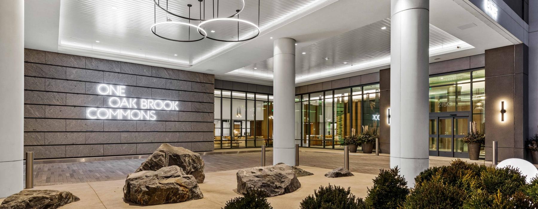 a building with a sign and plants in front of it